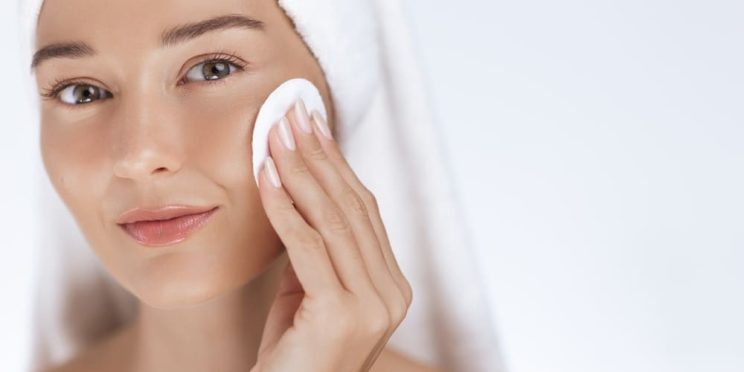 Woman cleansing face