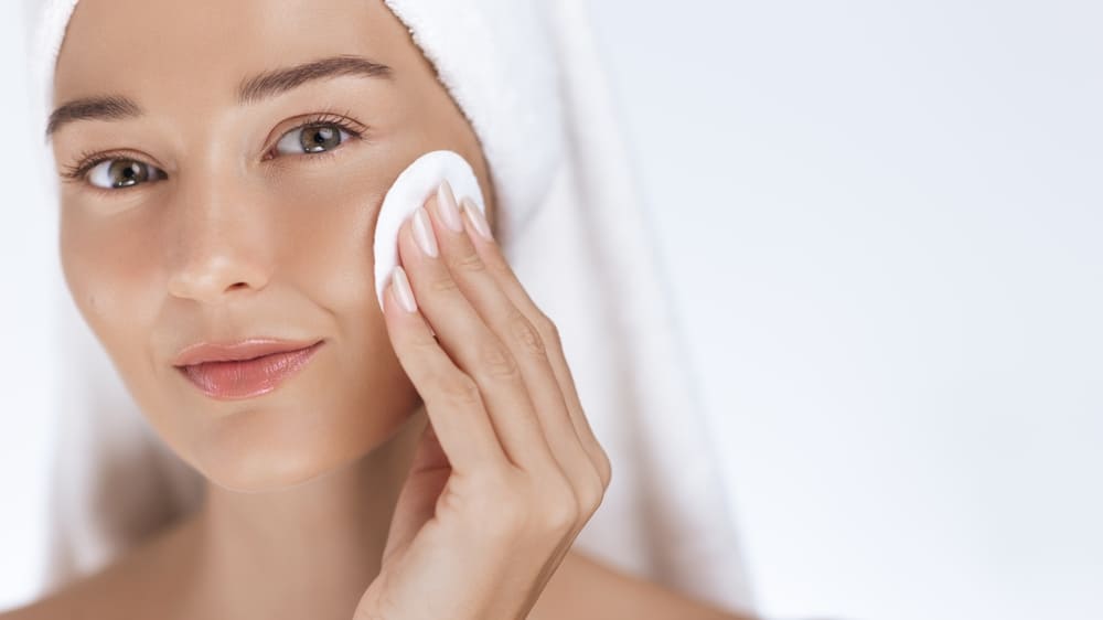 Woman cleansing face