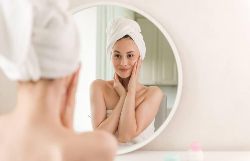 Woman looking at skin in mirror