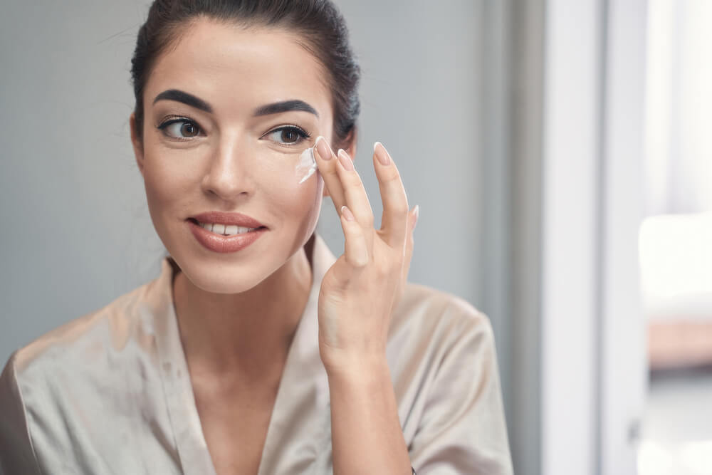 Woman using cream after reading VouPre eye cream reviews