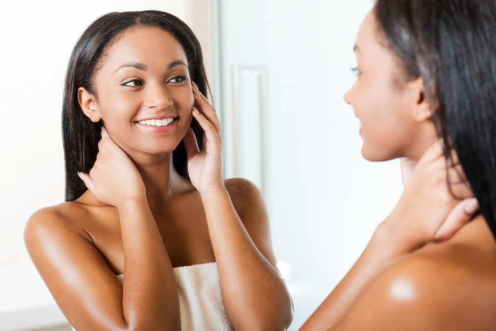 Woman looking at skin in mirror