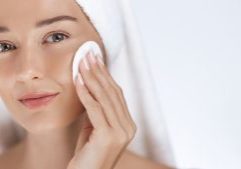Woman cleansing face