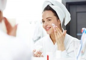 Woman applying day and night cream